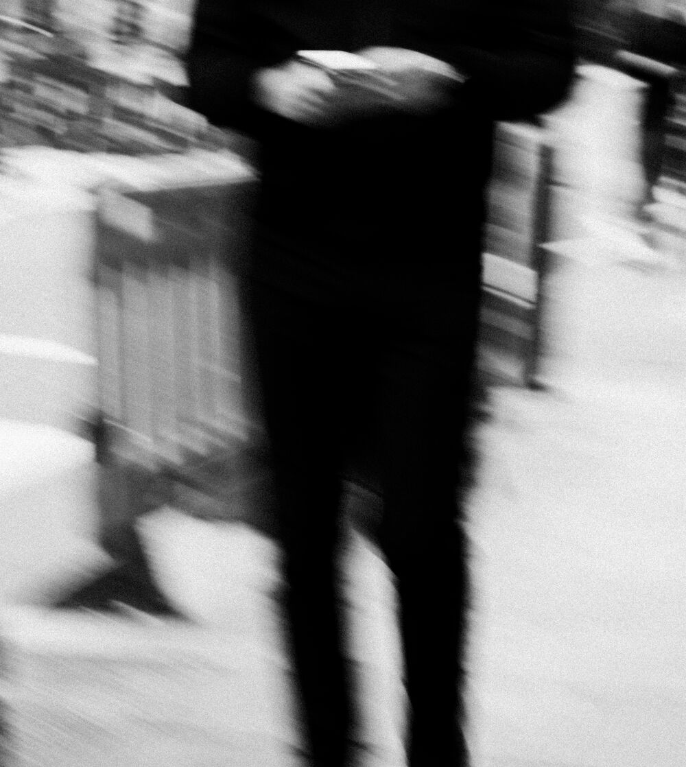 A person in motion on a city street, blurred