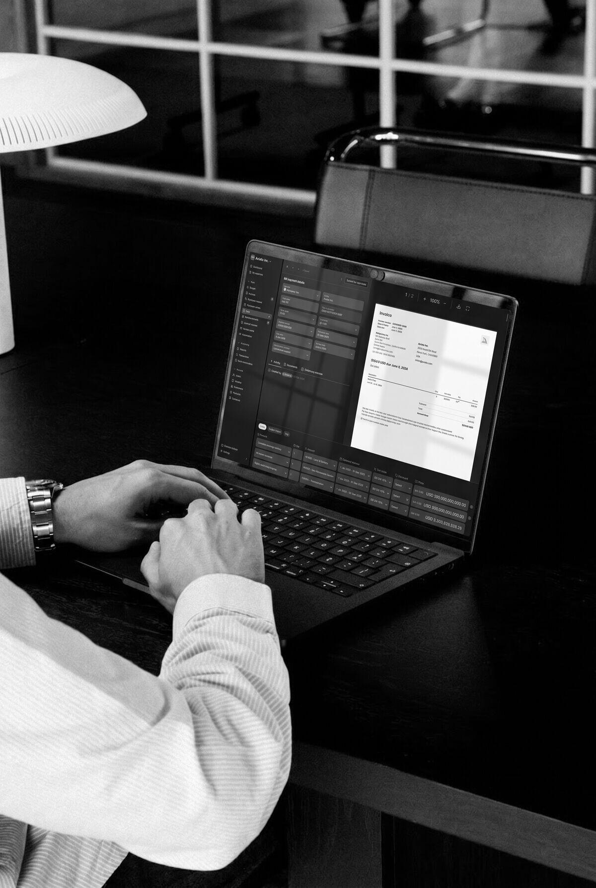 A person reviewing a bill in Light on a laptop at a dark desk