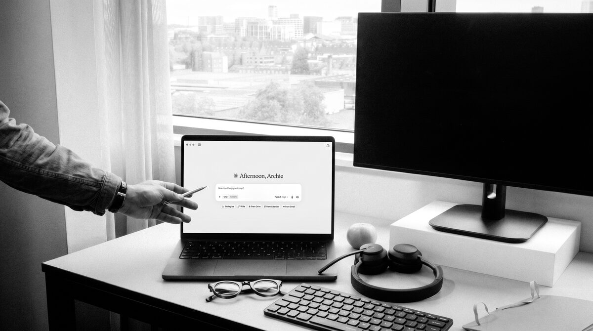 A desk by a window with Claude open on the laptop