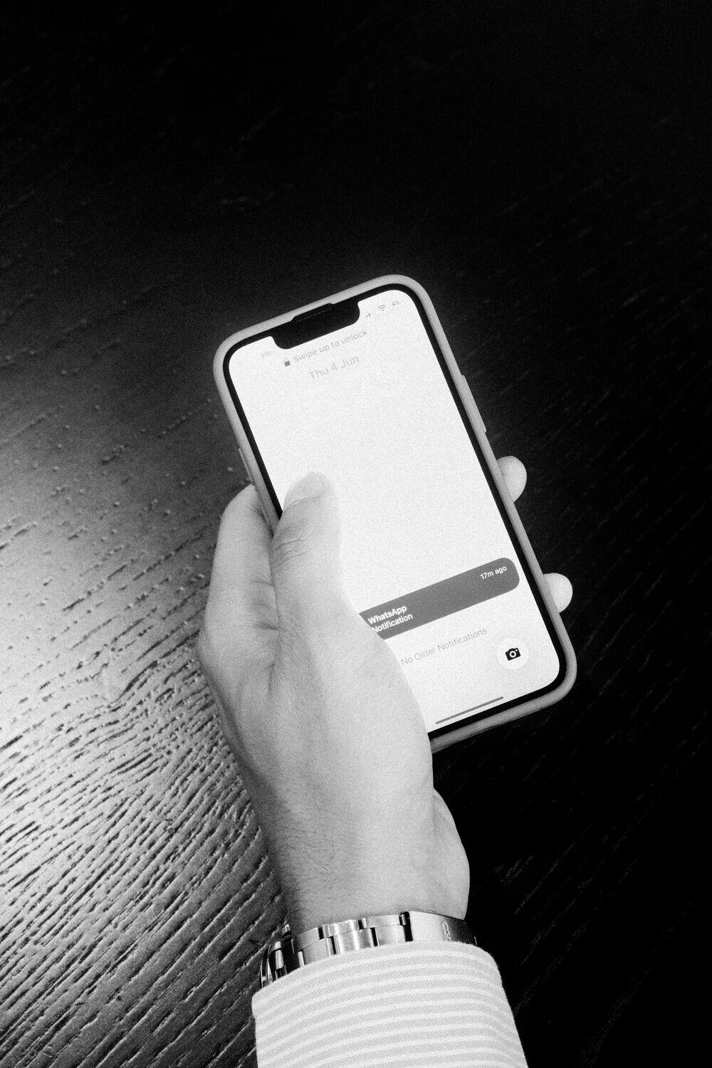 A hand holding a phone with the Light app on screen