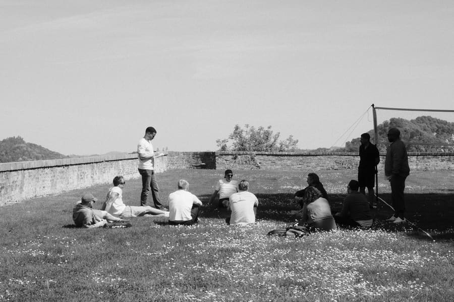 Teammates relaxing together on a grassy hilltop lawn