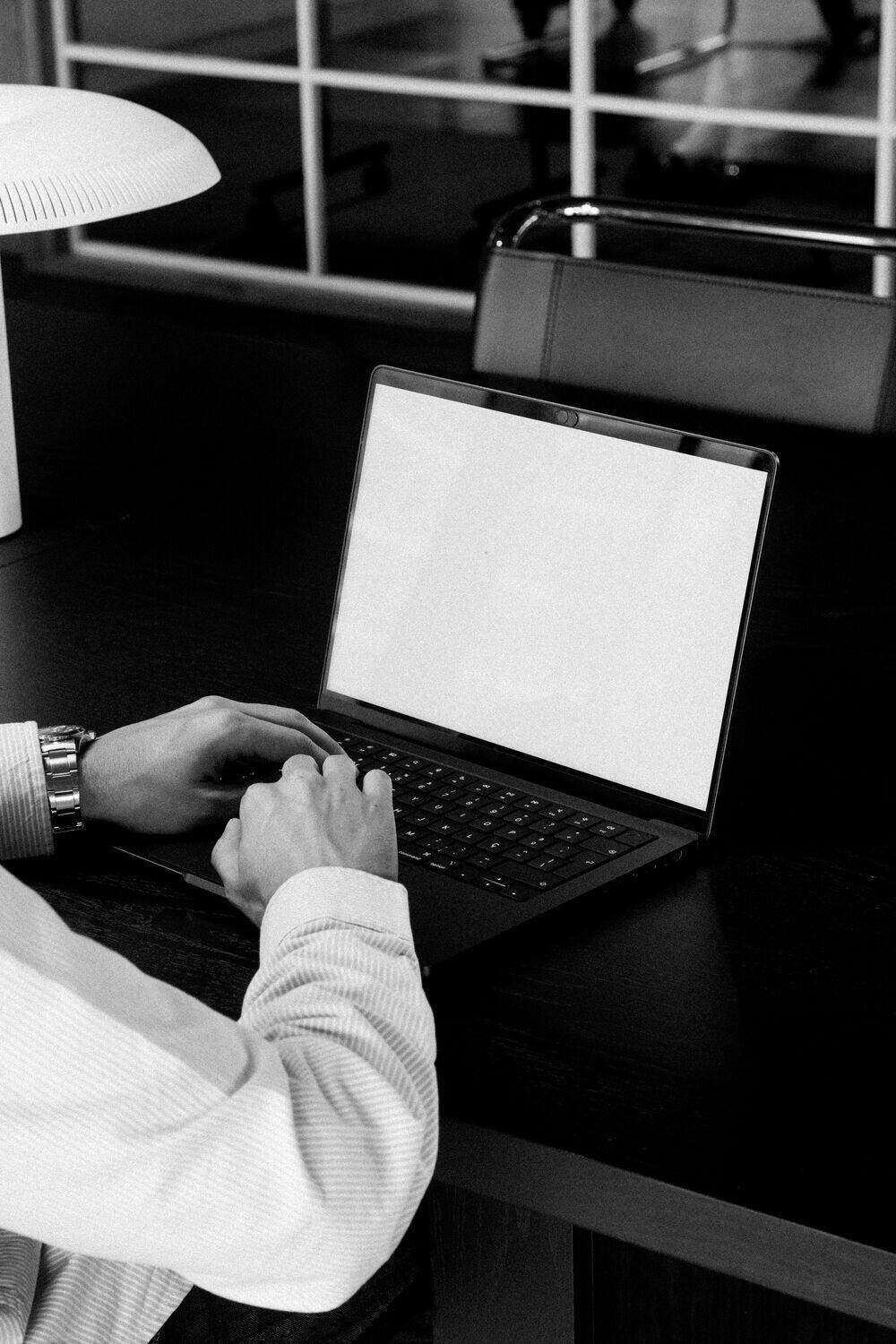 Hands typing on a laptop