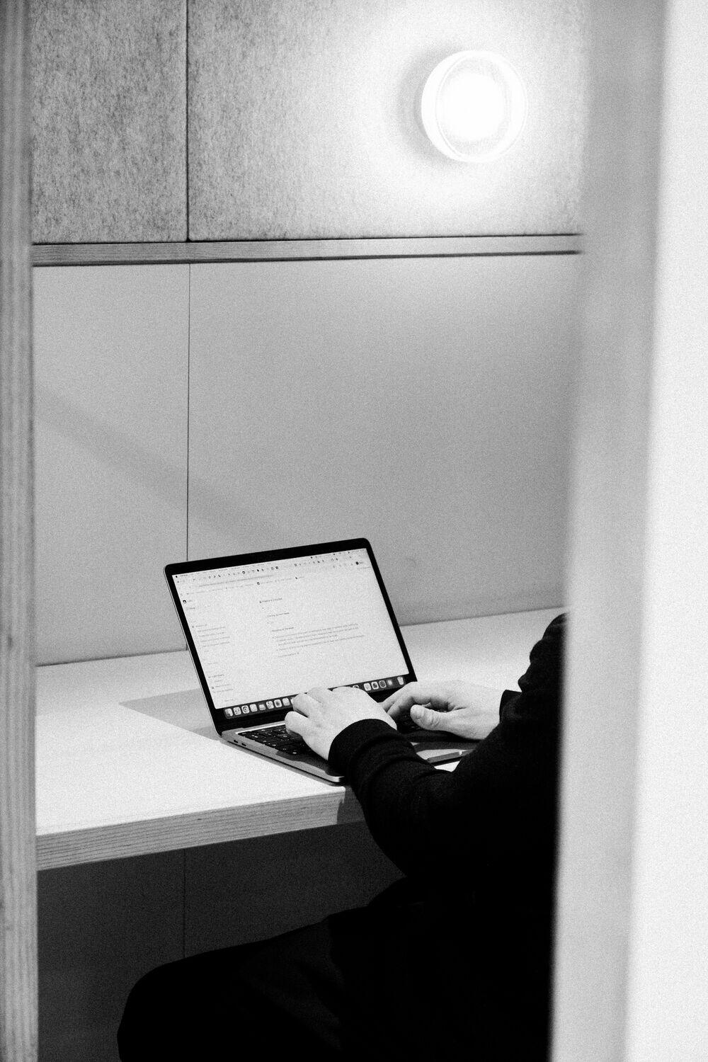 A person working on a laptop in a focus booth