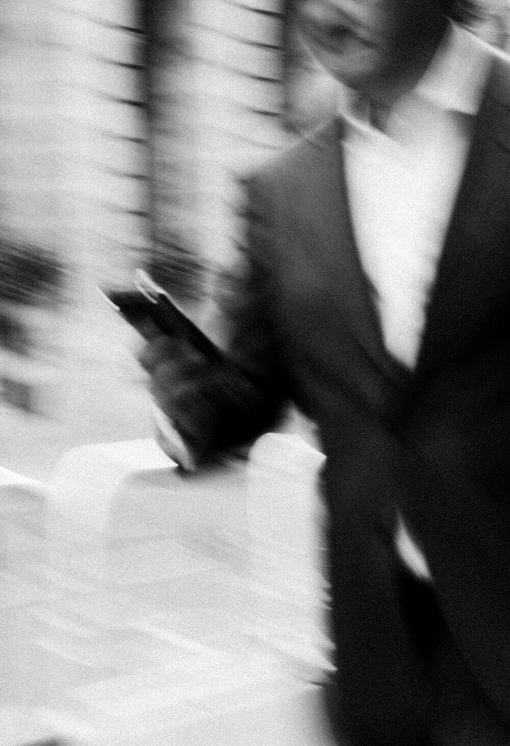A person approving on their phone while walking, motion-blurred